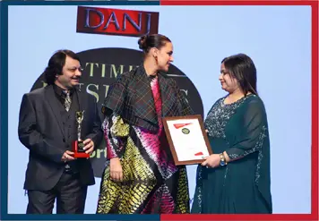 Dr. Shriyans Jain getting Times Business Award from Neha Dhupia